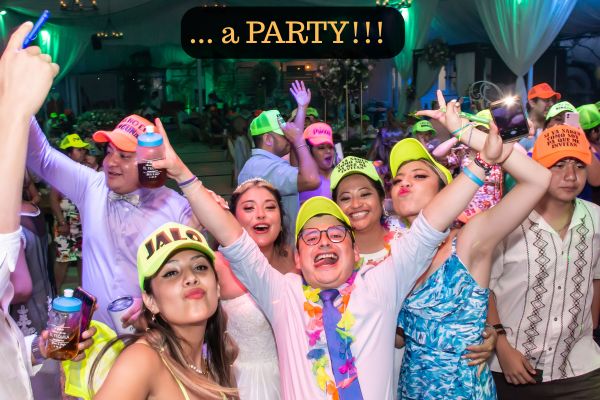 Lively wedding party at Jardín Allegra with guests dancing, colorful hats and lights on the dance floor.
