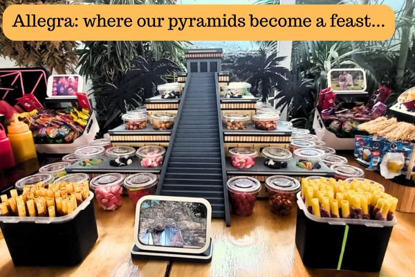 Snack and candy table at Allegra with a pyramid centerpiece, showing a creative Mexican-style food display.