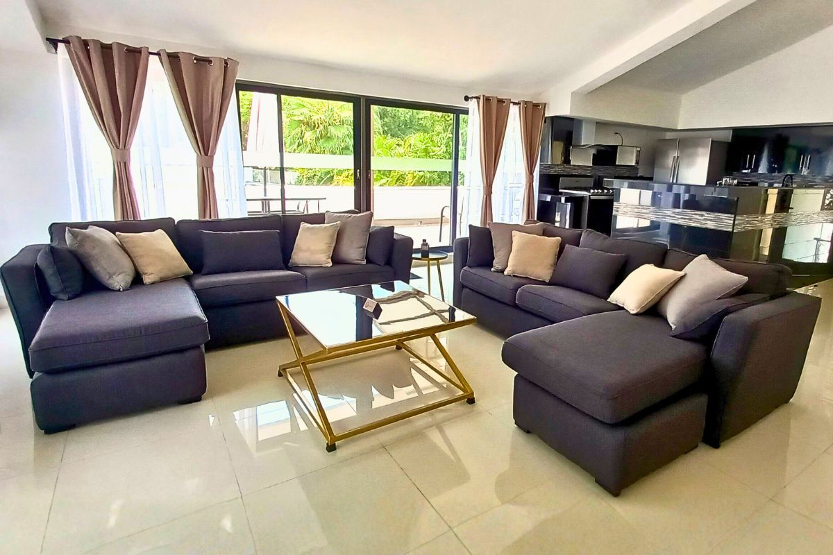 Sala moderna en Allegra Suites con cocina abierta, sofá en L y vista al jardín.