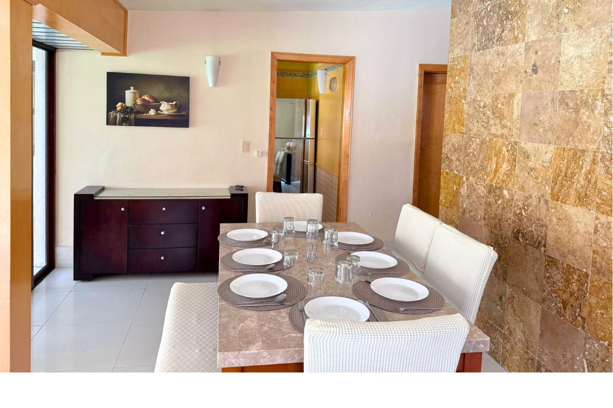 Comedor en Las Fuentes 34-A con mesa rectangular, sillas tapizadas y decoración cálida.