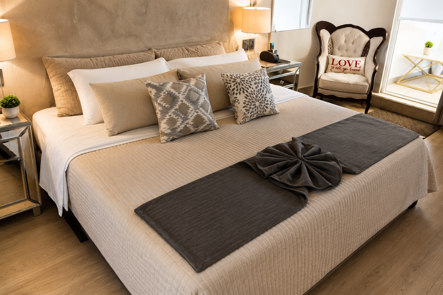 Master suite de Allegra Suites con cama king size, cabecera acolchada en tono beige y sillón de lectura, Allegra Homes en Cuernavaca, Morelos