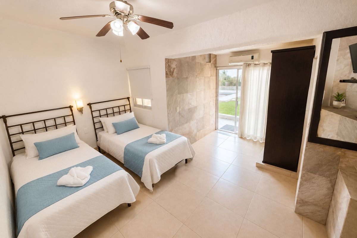 Recámara 4 de Villas Eucalipto con dos camas individuales, aire acondicionado, ventilador de techo y acceso al jardín, Allegra Homes en Cuernavaca, Morelos