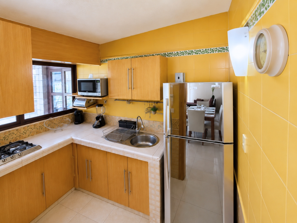 Cocina en L con azulejo amarillo y campana extractora circular, casa Las Fuentes 34-A en Cuernavaca