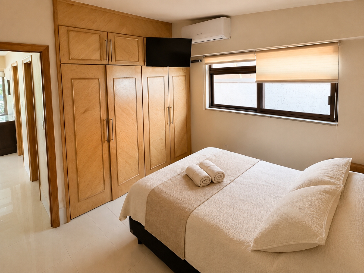 Recámara con cama matrimonial y cloáset de madera clara, casa Las Fuentes 34-A en Cuernavaca