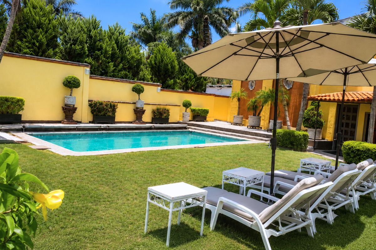 Camastros y alberca en el jardín de Villa Las Fuentes, Cuernavaca