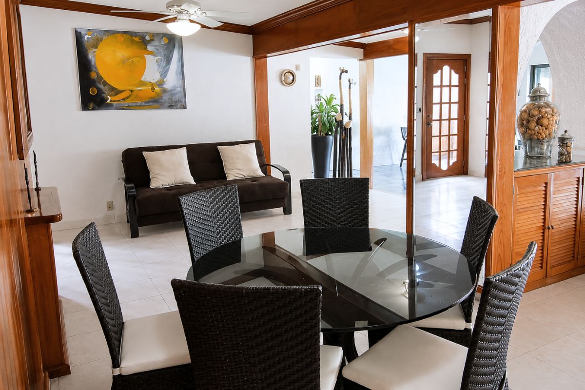 Antecomedor con mesa de vidrio y sala de estar en Villa Las Fuentes, Cuernavaca