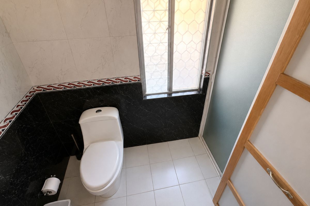 Baño con azulejo negro y detalles en talavera en Villa Las Fuentes, Cuernavaca