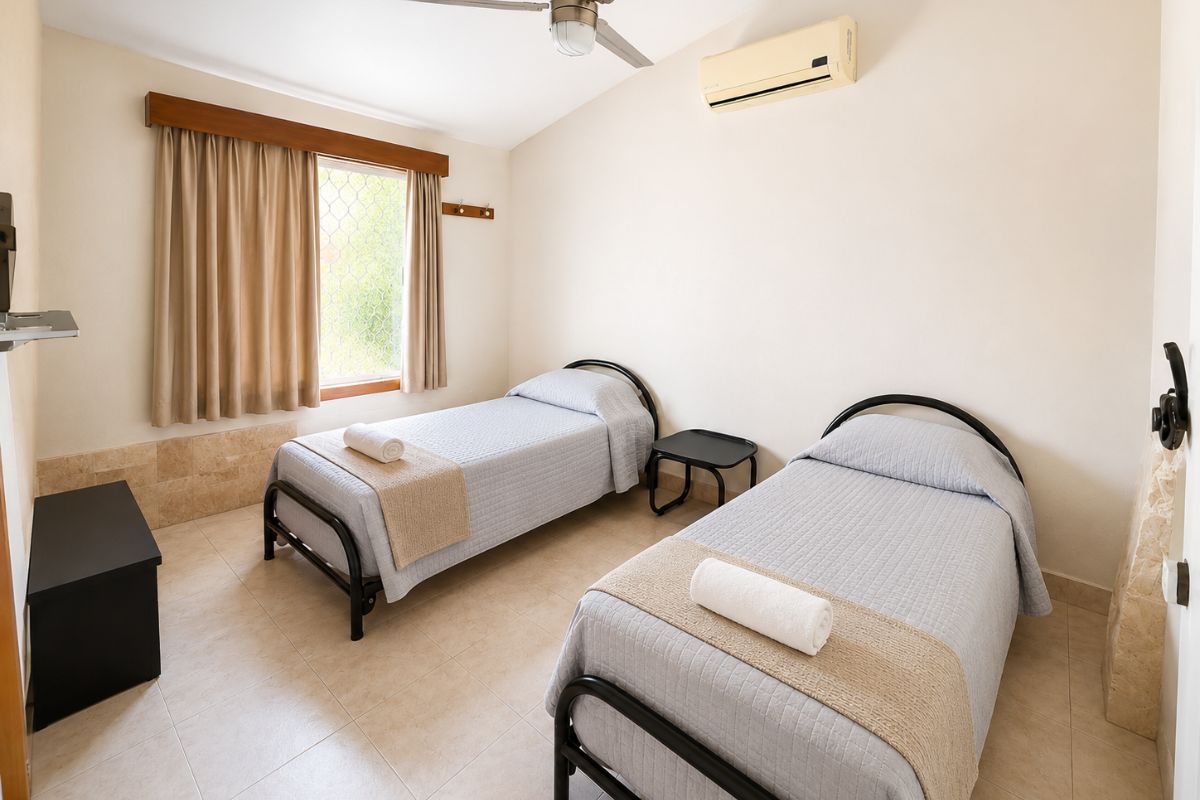 Recámara con dos camas individuales y aire acondicionado en Villa Las Fuentes, Cuernavaca