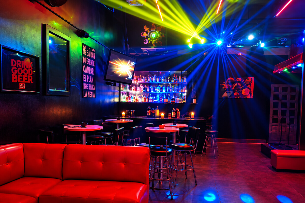 Interior de PRIVE con barra, sofás rojos y luces de discoteca en Villa las Fuentes de Allegra Homes, Cuernavaca